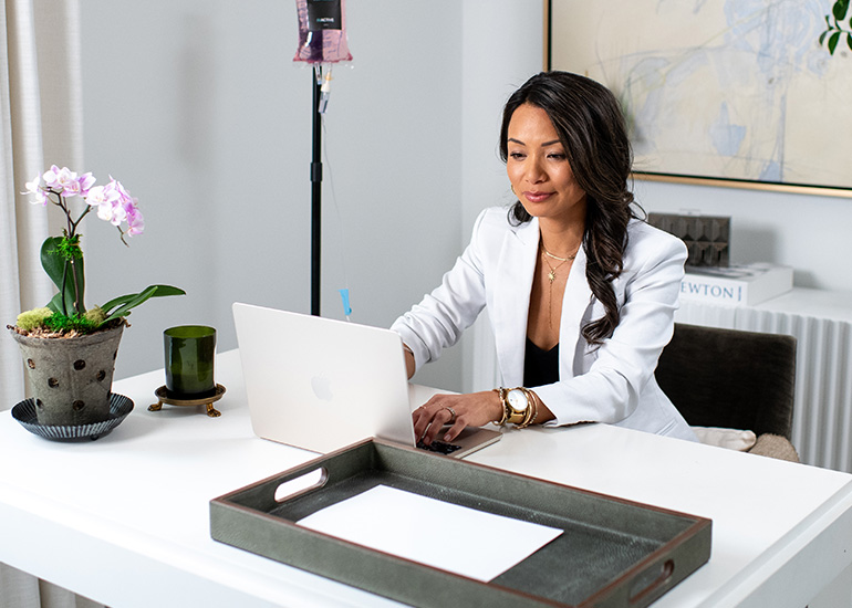IV Therapy Energy Clarity About (Desktop) Woman receiving IV therapy while working from home