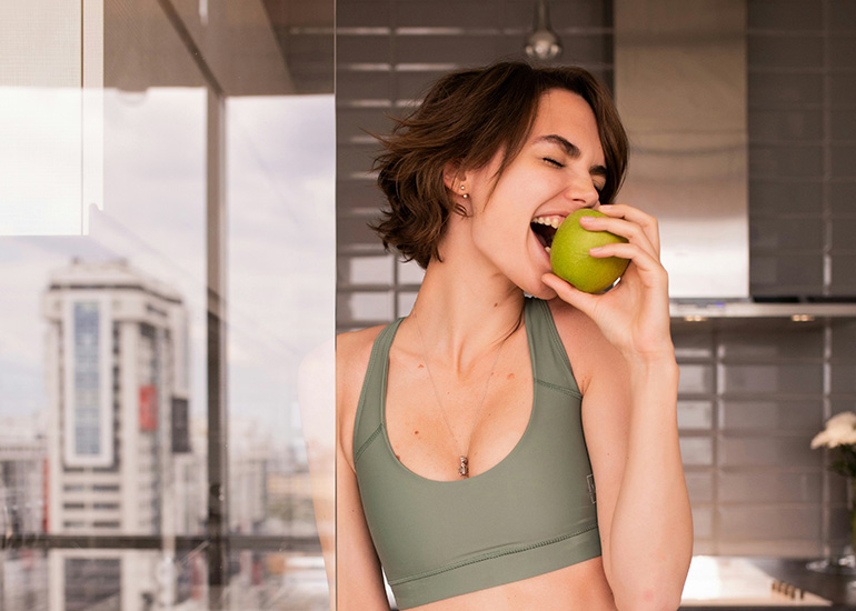 IV Therapy Essential Wellness (Desktop) Woman eating fresh fruit as part of a healthy lifestyle