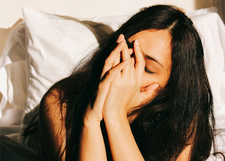 Woman resting in bed while feeling unwell